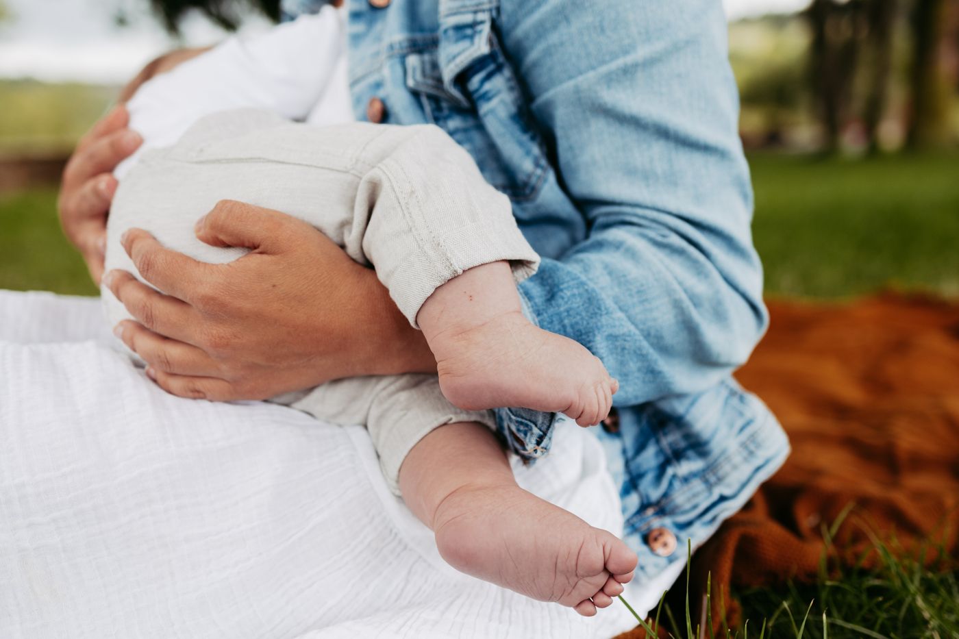 Kleine Babyfüße auf dem Schoß der Mama