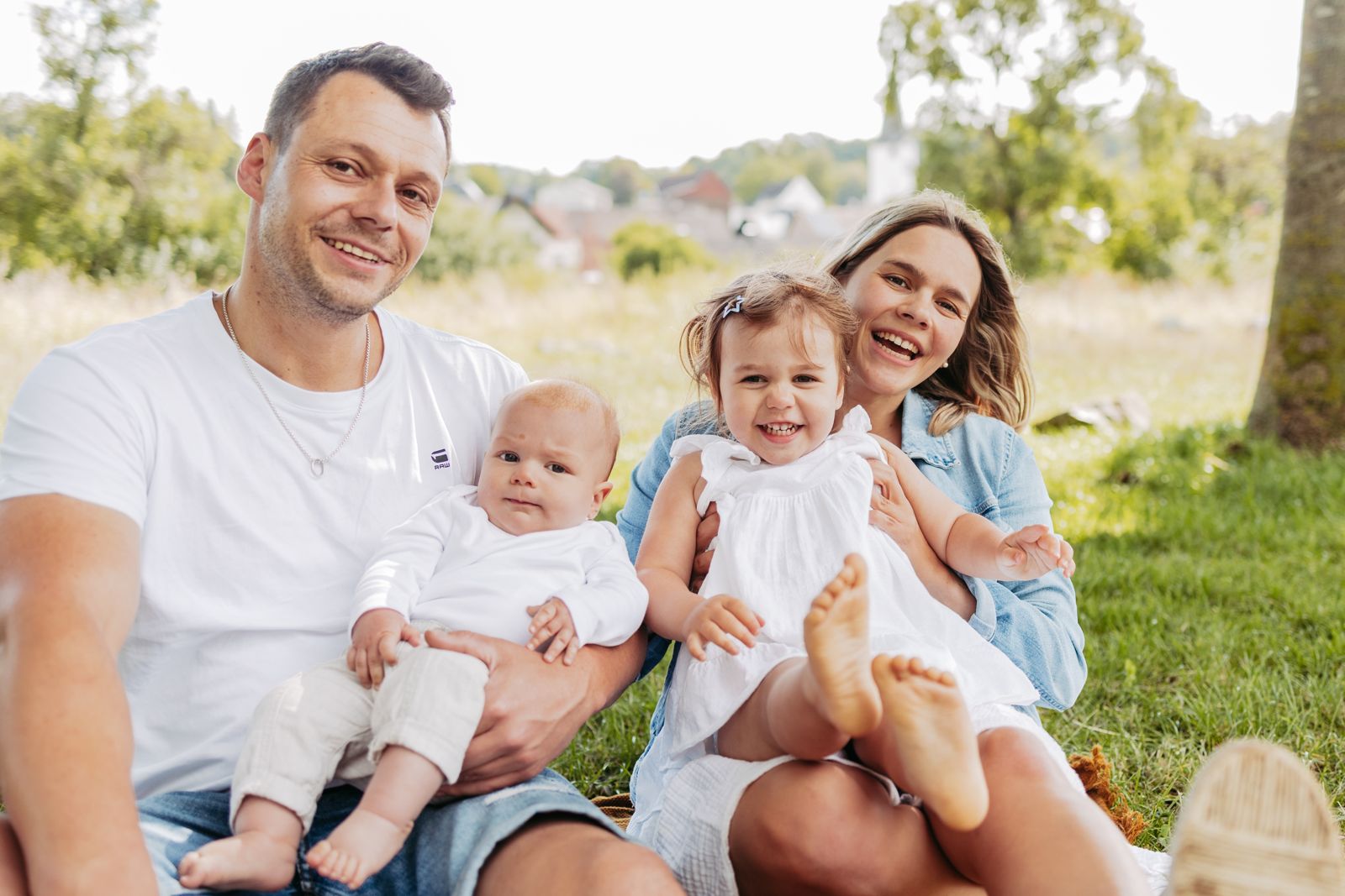 Franziska mit ihrem Mann und den beiden Kindern lachend auf einer Wiese